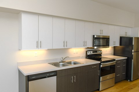 A modern kitchen with white cabinets and stainless steel appliances.