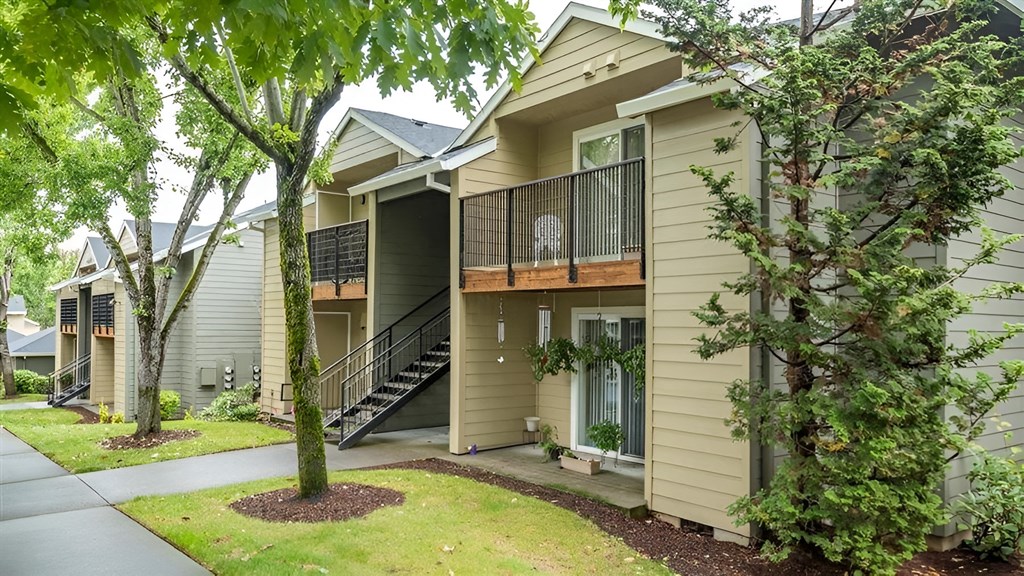 A tree is in front of a house.