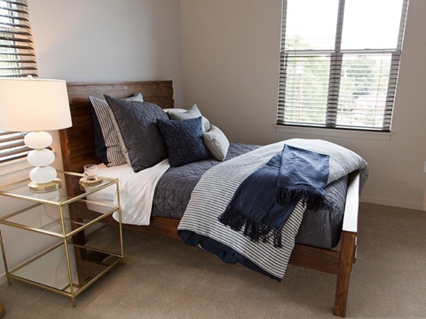 Bedroom with wooden furniture and gray linens at Northwood, Portland, 97217