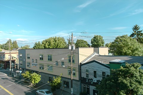 A street view of a small town with buildings and a car.