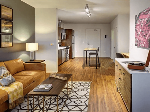 a living room and kitchen with a couch and a table