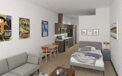 A living room with a grey couch, a coffee table, a bed, and a kitchen area.