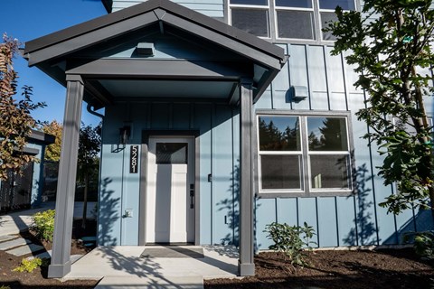 A blue house with a white door and windows.