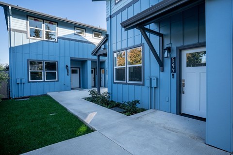 A blue house with a white door and windows.