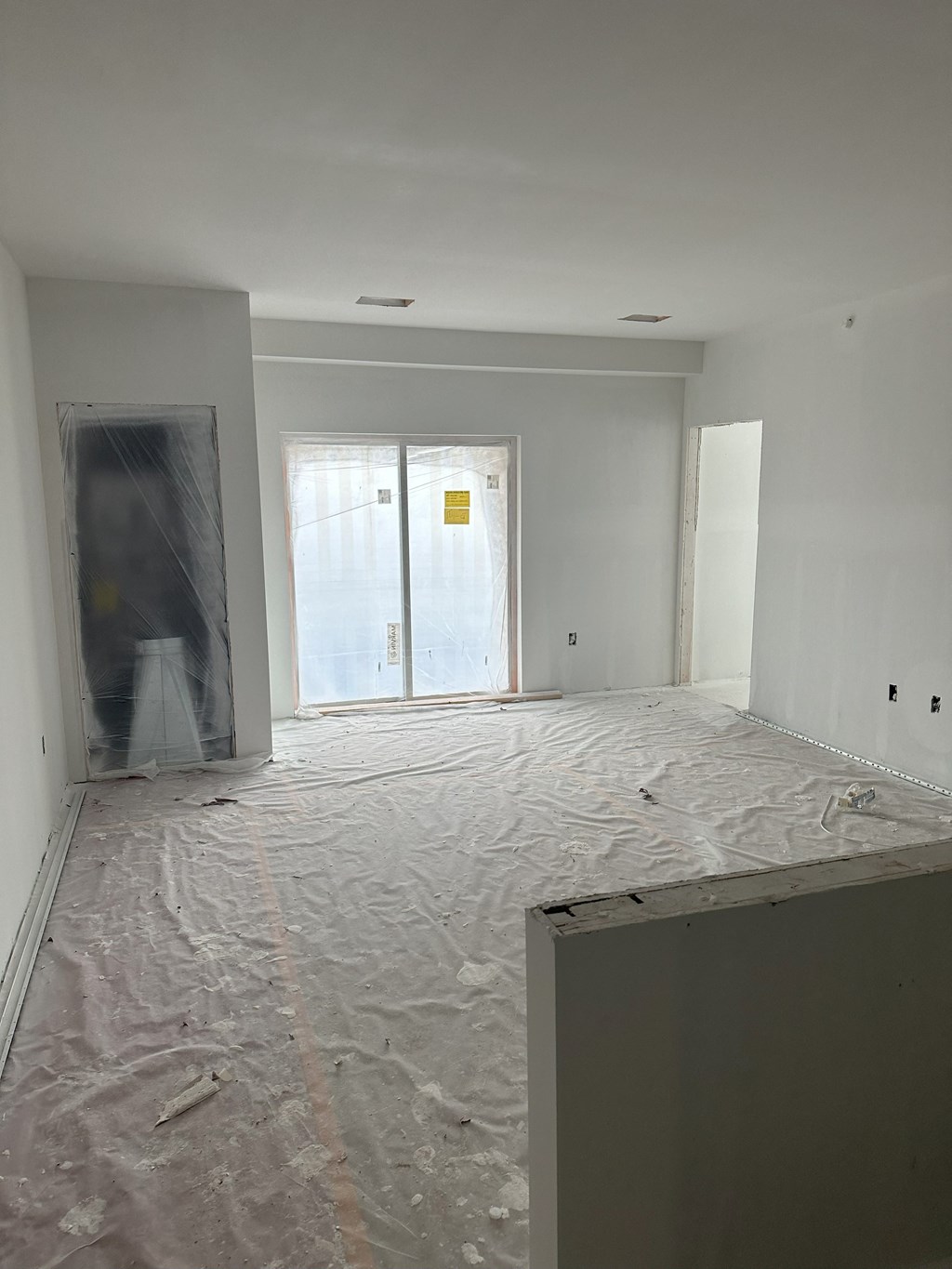 the living room is being remodeled and the floor is covered in plastic and the