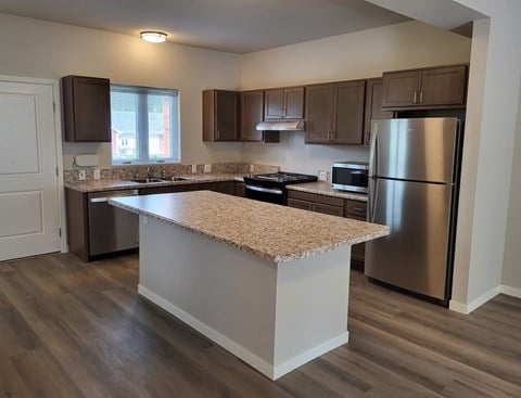 A kitchen with a granite countertop and stainless steel appliances.
