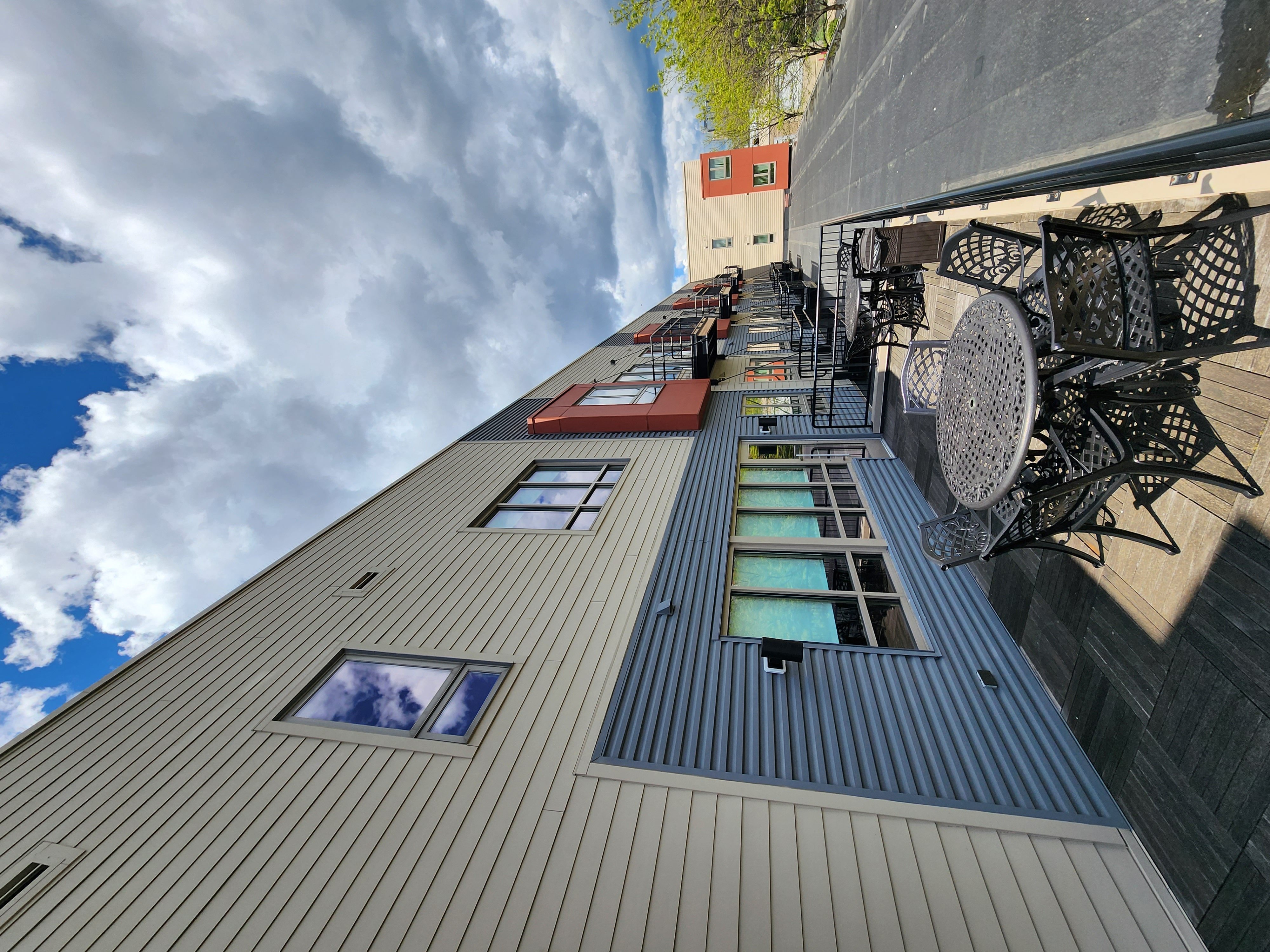 the side of a building with windows and a cloudy sky