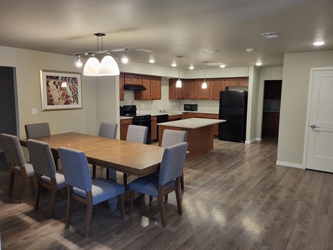 a dining room and kitchen with a wooden table and chairs