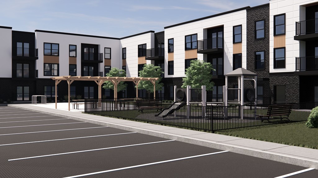 A row of modern townhouses with a parking lot in front.