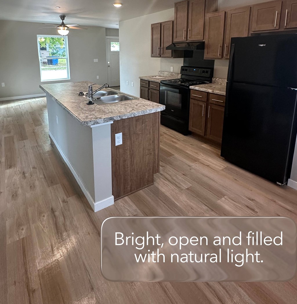 A kitchen with a black fridge and a black stove.
