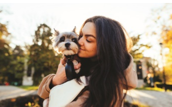 a woman holding a small dog in her arms at The Daniels at Northern Gateway Apartments, Saukville, WI 53080