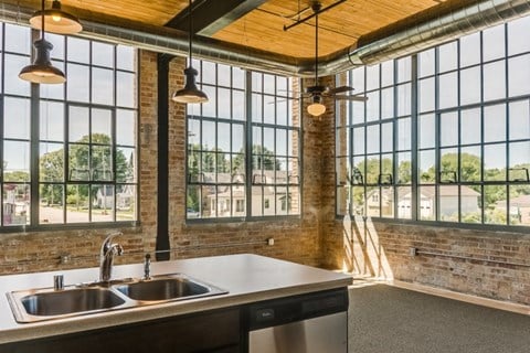 a kitchen with a sink and large windows