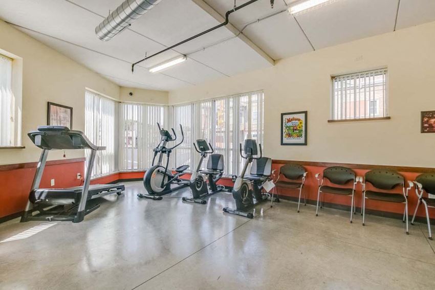 Interior a gym with cardio equipment and chairs in a room with windows