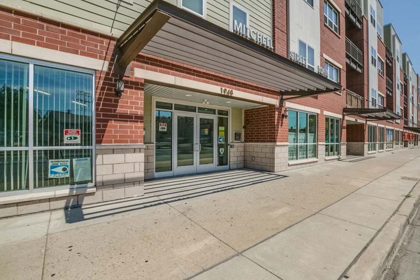 Exterior a brick building with glass doors and a sidewalk
