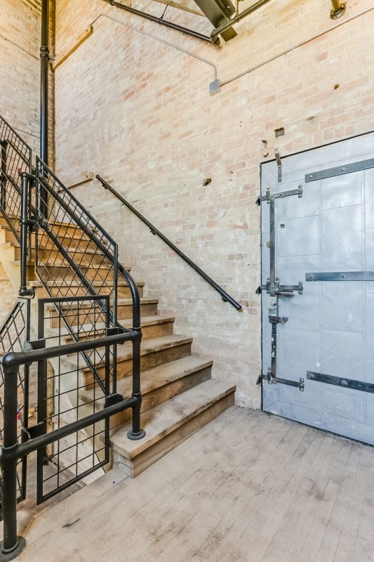 The stairway to the second floor of the building with a blue door