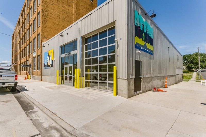 The front of a building with a large glass door and a sign on the side