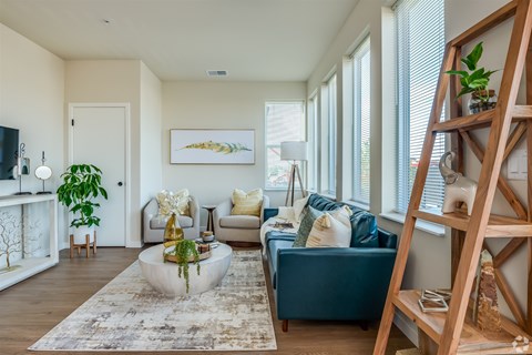 A living room with a blue couch and a white coffee table.