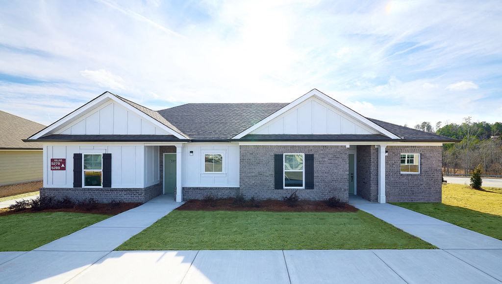 the front of a brick house with a lawn