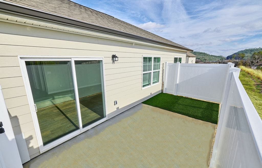 a patio on the side of a house with a fence