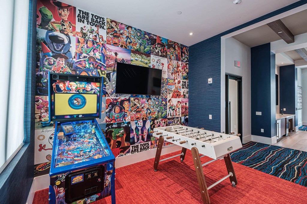 a gaming room with a wall of comic books and a television at Altis Blue Lake, Lake Worth, Florida