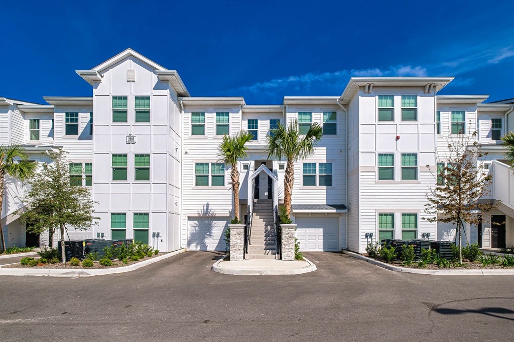 a large white building with palm trees in front of it