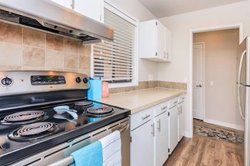 a kitchen with white cabinets and a stove top oven