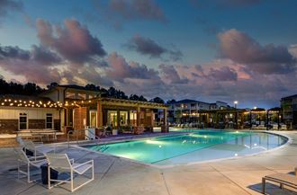 Two BR Apartments in Norcross, GA - The Darnell - Pool with Lounge Chairs, Tables, and Clubhouse in Background