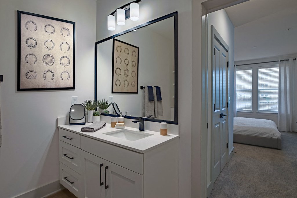 a white bathroom with a large mirror and a sink