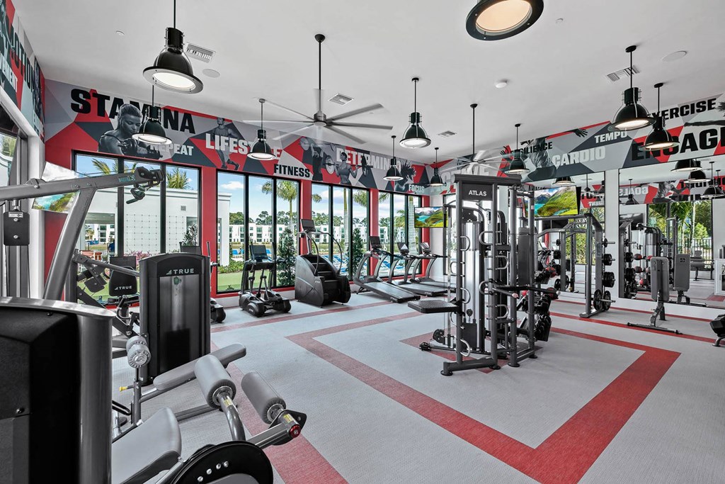 a gym with a lot of equipment and windows at Altis Blue Lake, Lake Worth, FL, 33467