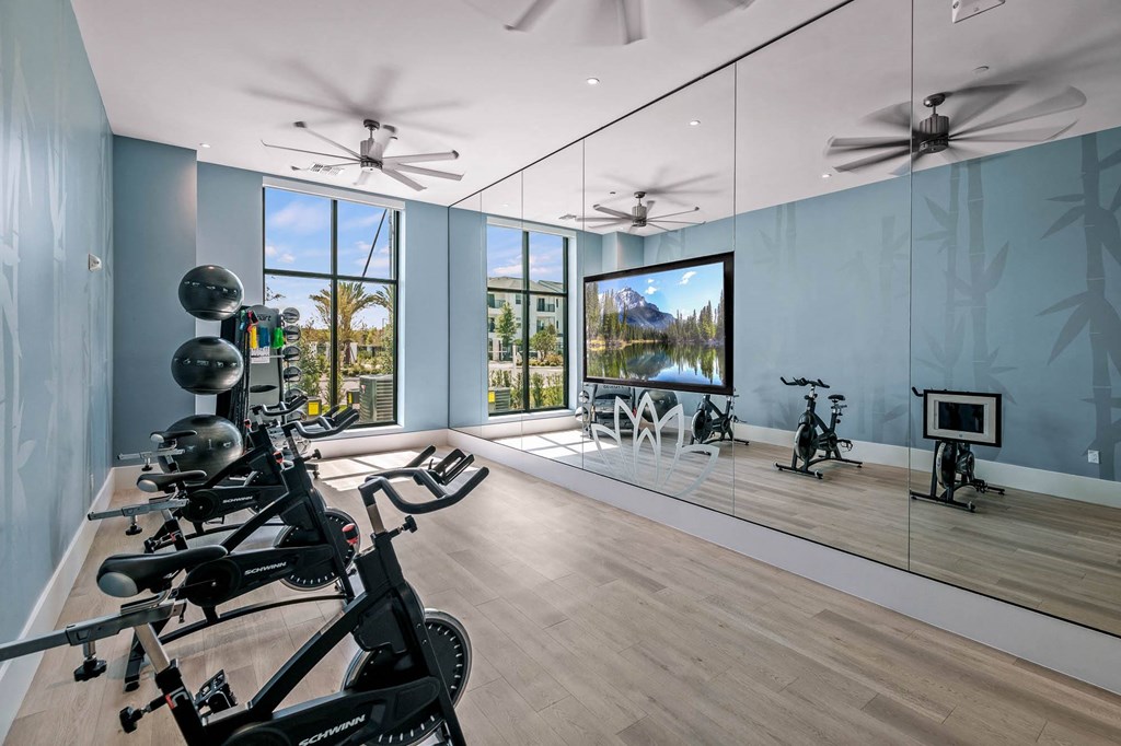 a workout room with mirrors and weights on a wooden floor
