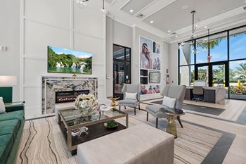 A modern living room with a green sofa, a coffee table, and a large TV displaying a nature scene.