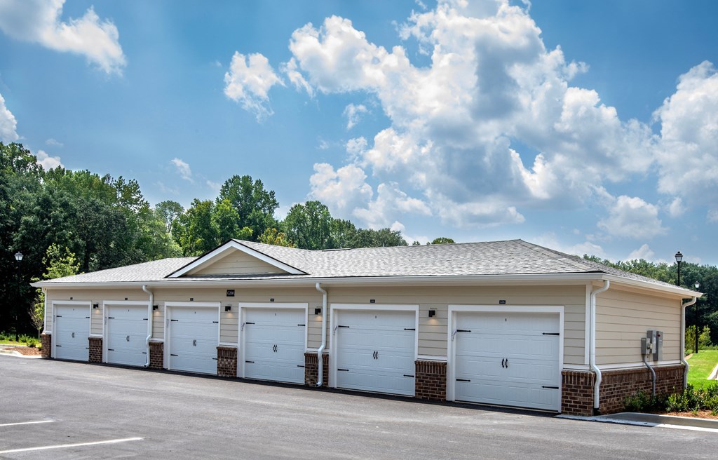 a row of white garages with a gray roof