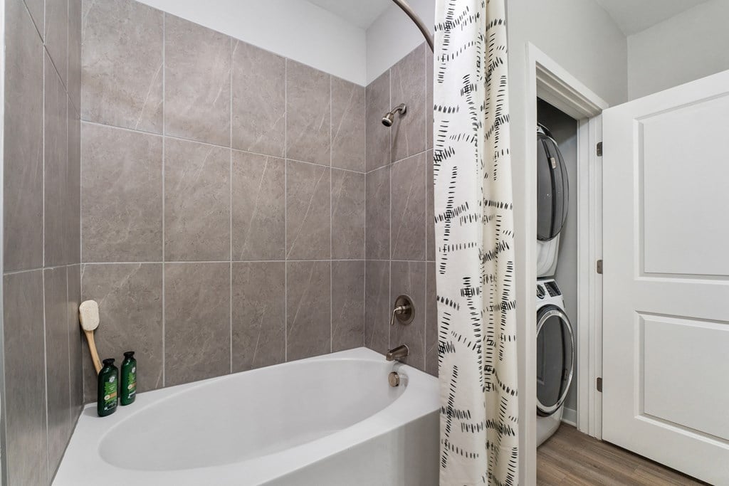 A bathroom with a white tub and a shower curtain.