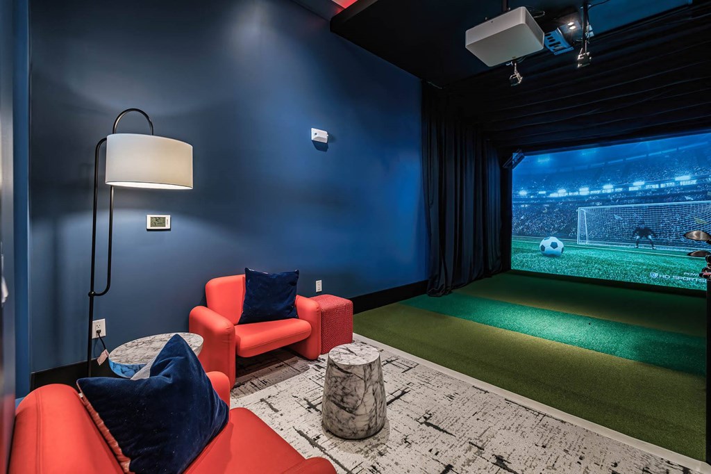 a game room with a soccer field and a projector