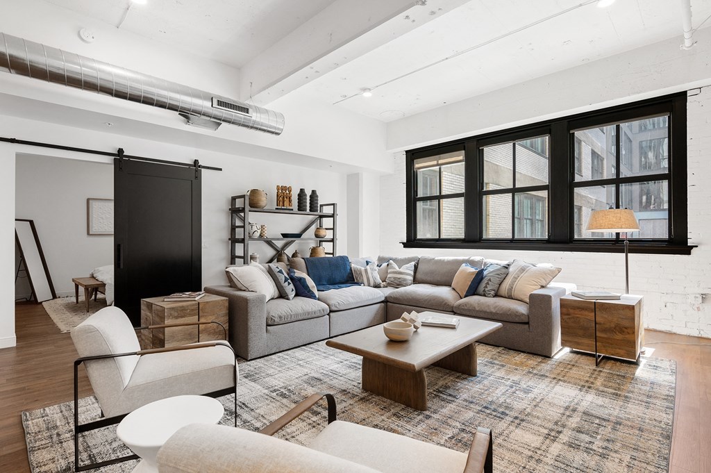 a living room with a large couch and a coffee table in front of a window