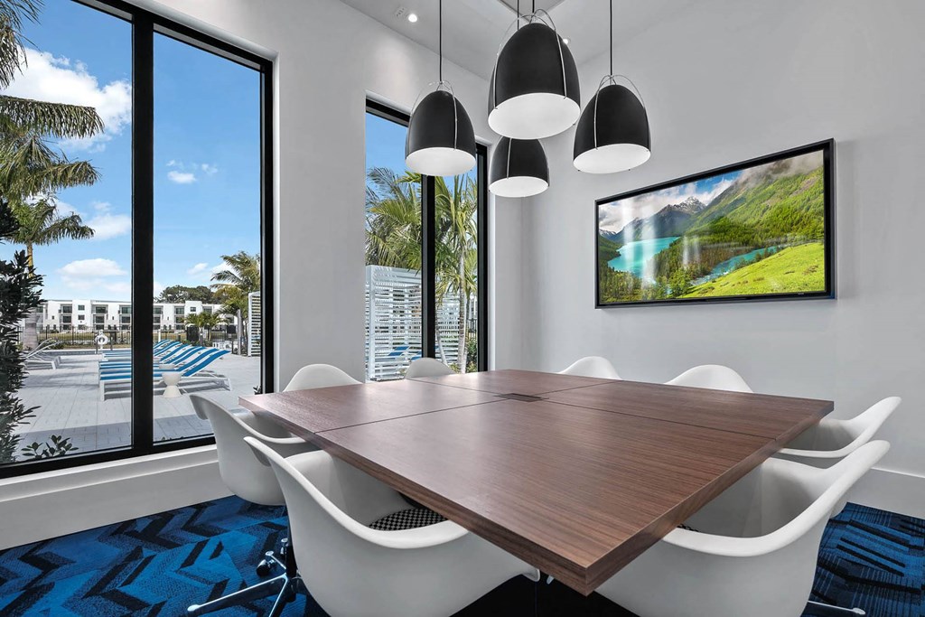 a dining room with a large window and a table with chairs at Altis Blue Lake, Lake Worth, Florida