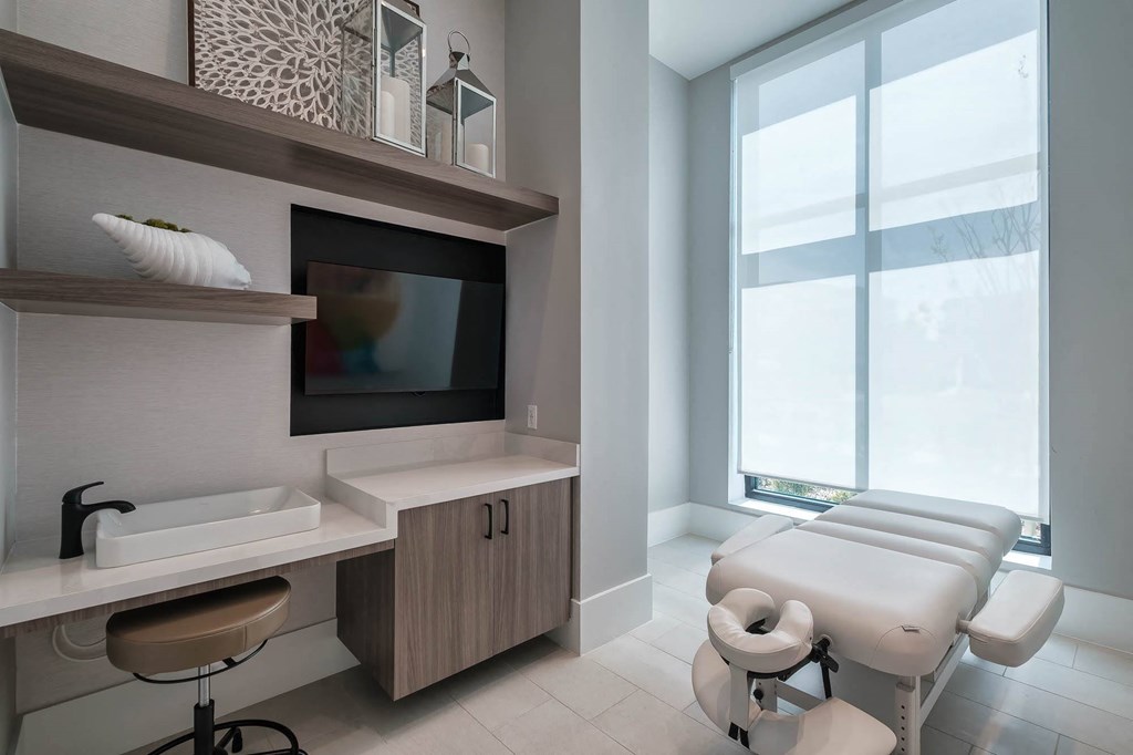 a treatment room at a hospital with a large window and a sink and a chair