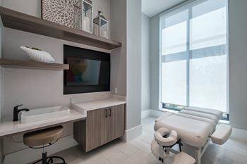 a treatment room at a hospital with a large window and a sink and a chair at Altis Grand Suncoast, Land O' Lakes