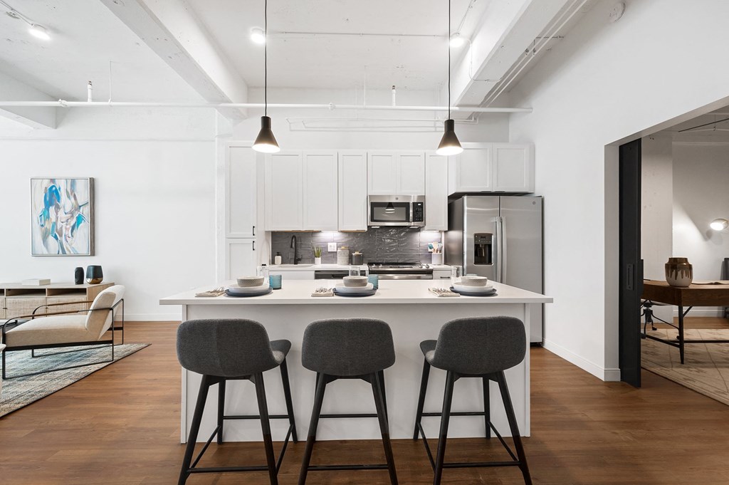a kitchen with an island and stools in a 555 waverly unit
