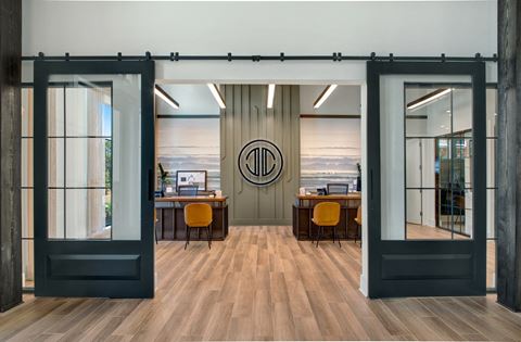 an open concept office with sliding glass doors and a logo on the wall