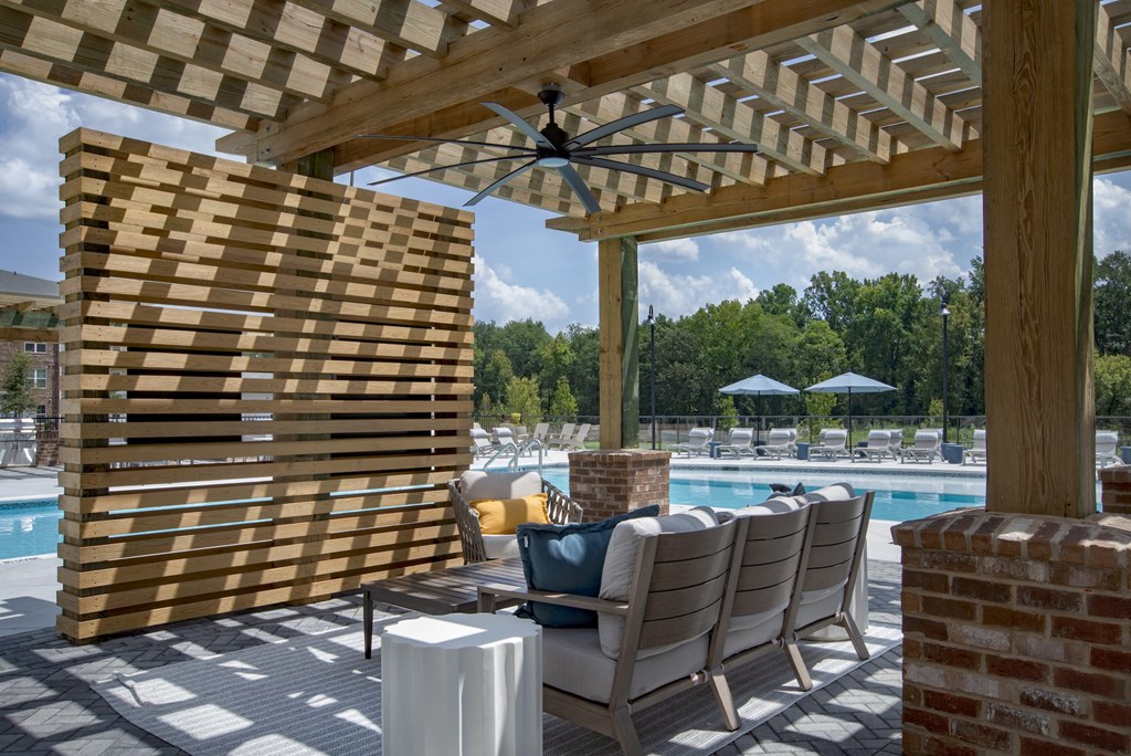 a pergola with a pool in the background