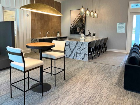 a kitchen with a marble counter top and a bar with chairs