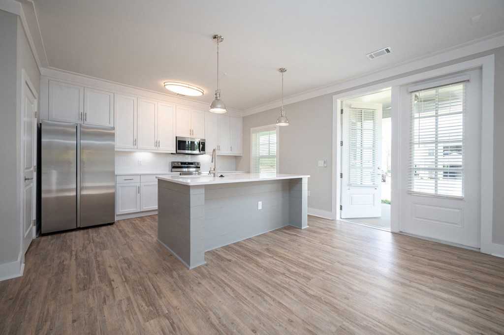 a kitchen with white cabinets and a large island