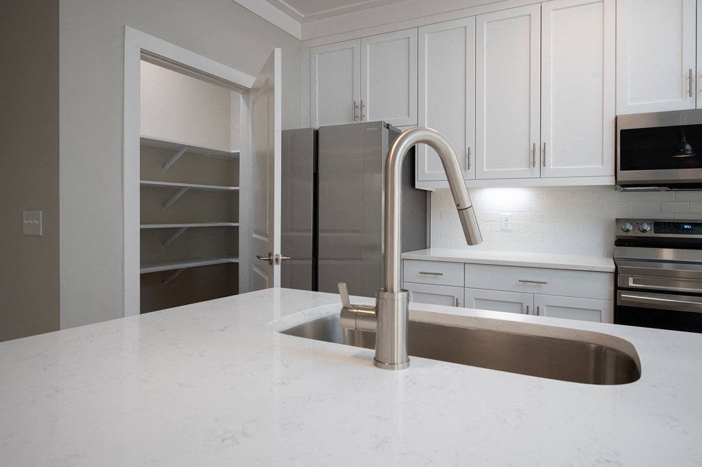 a kitchen with white cabinets and a white counter top