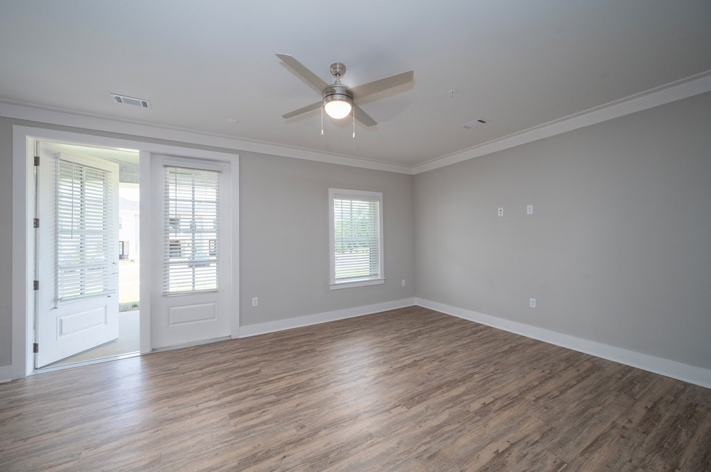a bedroom with a ceiling fan and a door to a patio