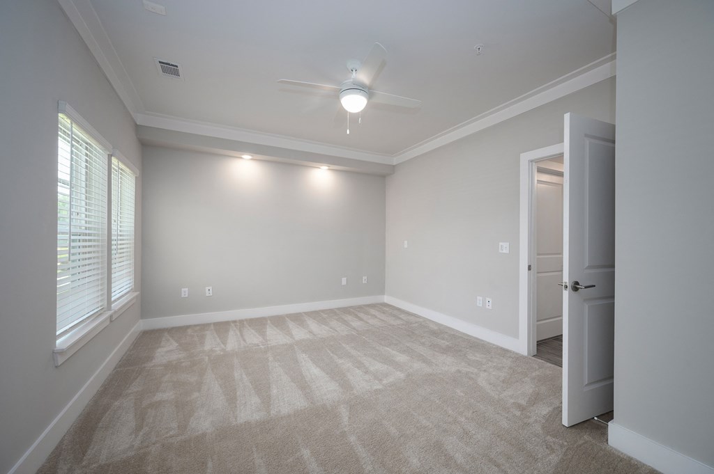 an empty bedroom with a ceiling fan