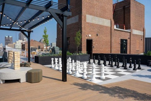 a giant chess board on a patio in front of a brick building