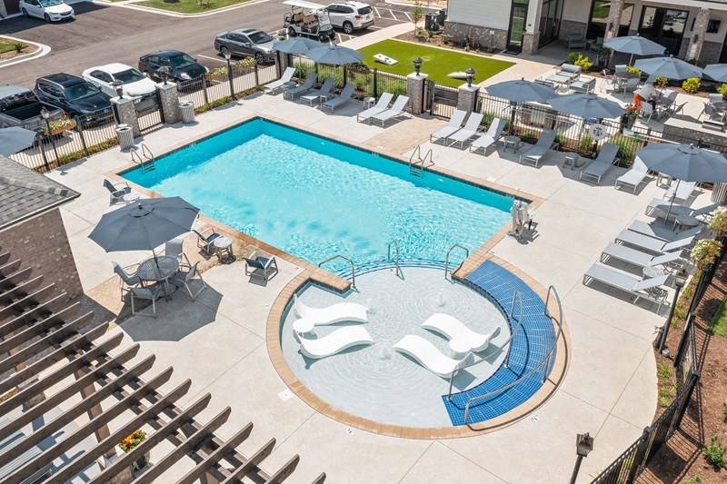 a swimming pool with chairs and umbrellas next to a hotel pool