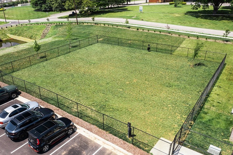 a parking lot with cars parked next to a grass field