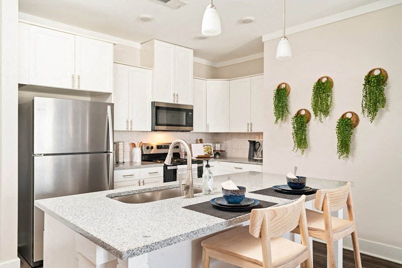 a kitchen with a granite counter top and a stainless steel refrigerator